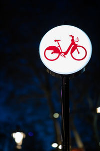 Close-up of road sign at night