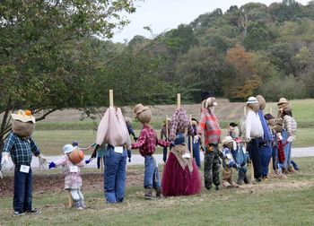 People standing on field against trees