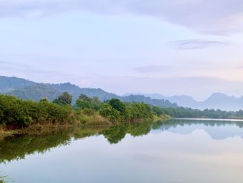Scenic view of lake by trees against sky