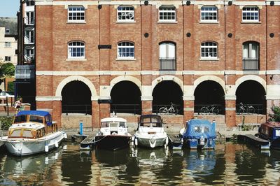 Boats moored in canal along buildings