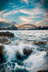 View of bridge over sea against cloudy sky