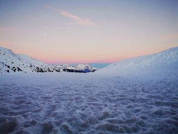 Scenic view of snowcapped mountains against sky during sunset