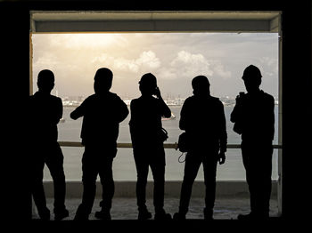 Silhouette people standing against sky