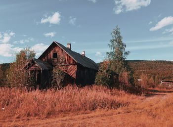 Abandoned house on field against sky