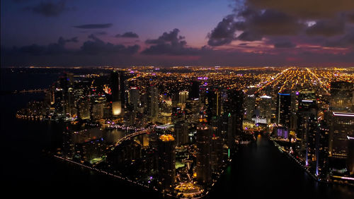 Illuminated buildings in city against sky at night