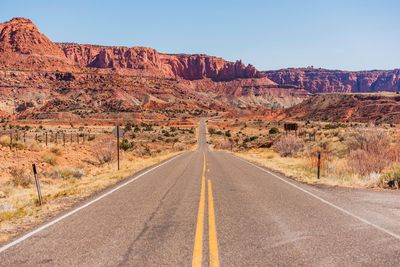 Road leading towards mountains against sky