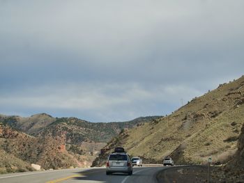 Cars on road against mountain range