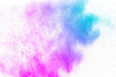 Defocused image of multi colored powder paints against white background