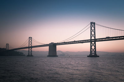 Bay bridge against clear sky at sunrise