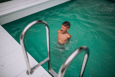 High angle view of shirtless man in swimming pool