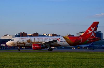 Airplane on airport runway against sky