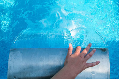 Midsection of woman swimming in pool