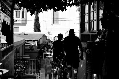 Rear view of silhouette people walking on street in city