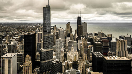 Aerial view of cityscape against cloudy sky