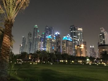 Illuminated buildings in city against sky at night