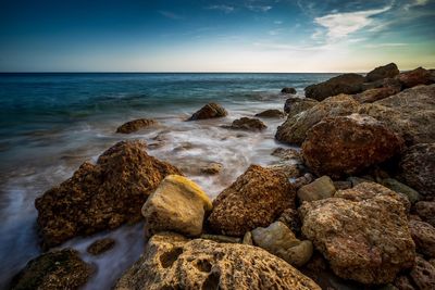 Rocks on beach against sky