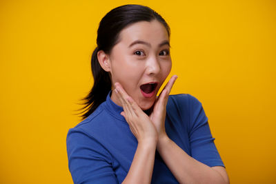 Portrait of woman against yellow background