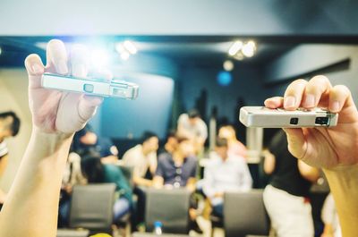 Close-up of hands holding cameras