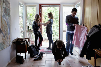 Family getting dressed in front of entrance door
