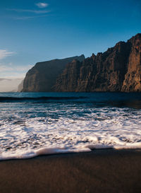 Scenic view of sea and mountains against sky