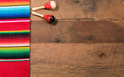 Directly above shot of serape and maracas on wooden table