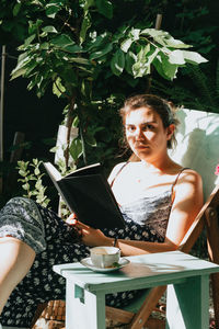 Portrait of woman sitting amidst plants