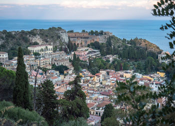 High angle view of townscape by sea against sky