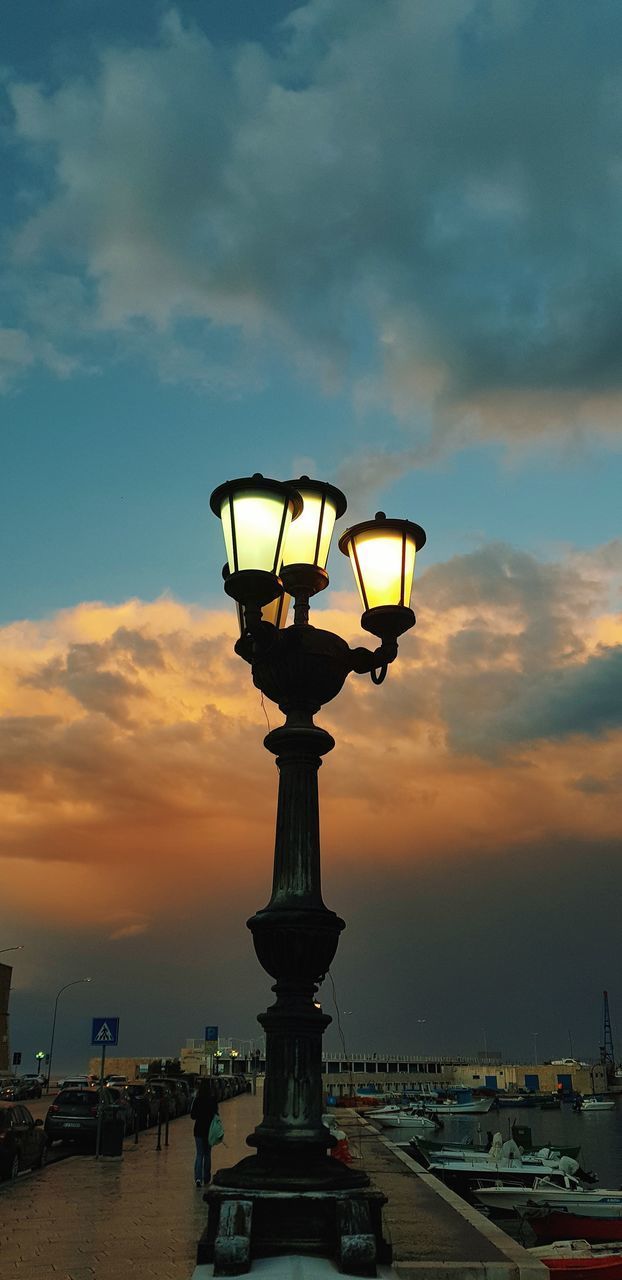 LOW ANGLE VIEW OF ILLUMINATED STREET LIGHT AGAINST CLOUDY SKY