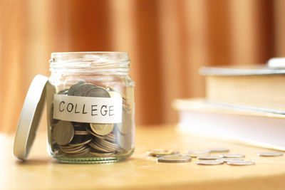 Close-up of coins in jar on table