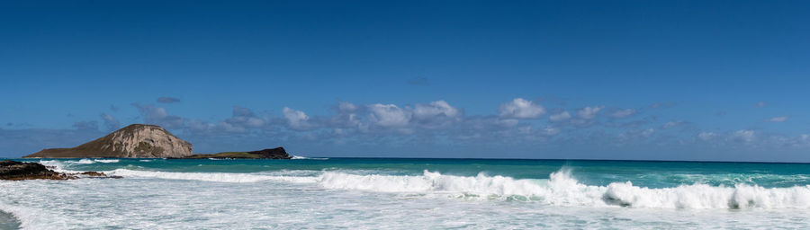 Panoramic view of sea against blue sky