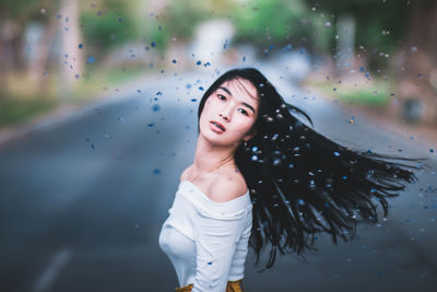 Beautiful young woman standing on road