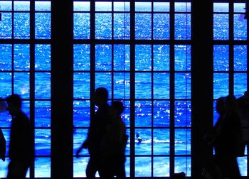 Silhouette man standing by window