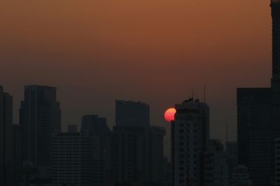 Buildings in city at sunset