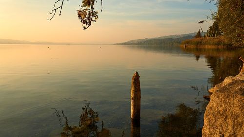 Scenic view of lake against sky at sunset