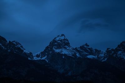 Scenic view of snowcapped mountains against blue sky at night