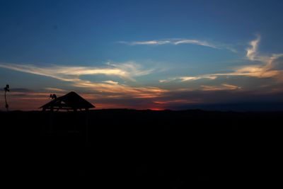 Silhouette built structure on landscape against sky