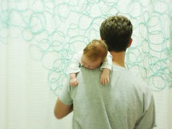 Father holding baby in living room