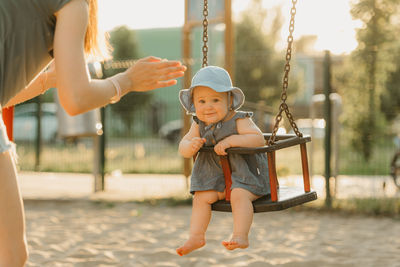 Full length of woman standing on swing