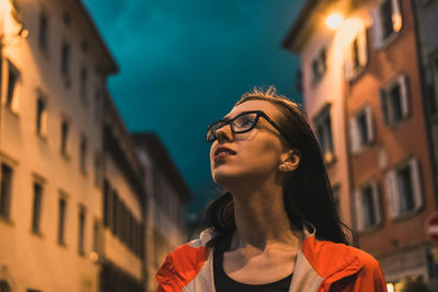 Young woman walking on street against sky at night