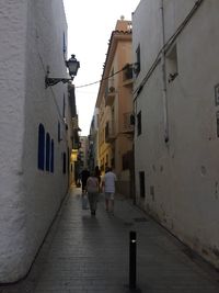 Rear view of people walking on street in city