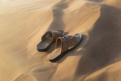 High angle view of shoes on sand at beach