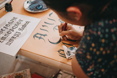 High angle view of woman holding paper with text