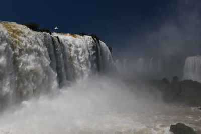 Scenic view of waterfall in sea against sky