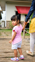 Woman standing with pink arms raised