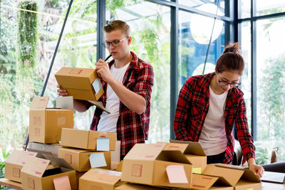 Coworkers packing boxes at desk in office