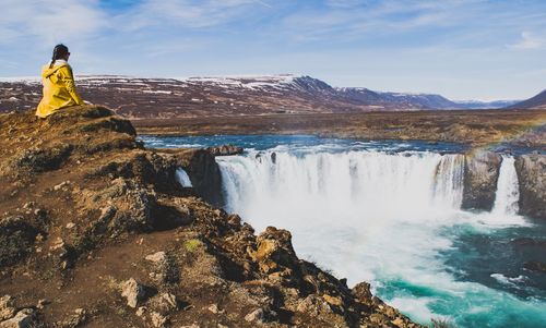 Scenic view of waterfall against sky