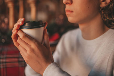 Portrait of candid authentic smiling handsome boy teenager using mobile phone at xmas home interior