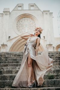 Young  beatiful woman standing against building