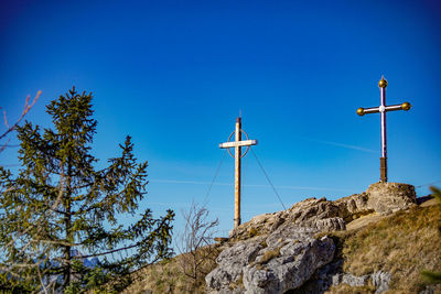 Low angle view of cross against clear blue sky