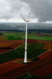 Windmills on field against sky